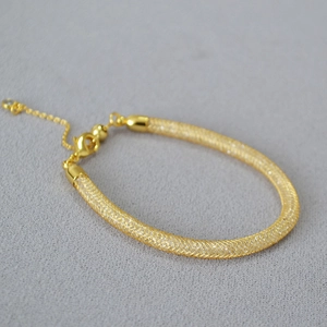 Detailed macro view of golden mesh chain with sparkling crystal filler and lobster clasp