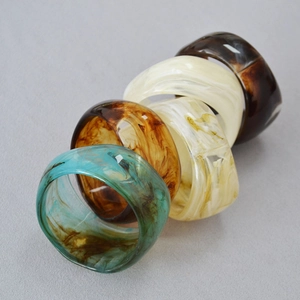 Lot de quatre joncs larges en acrylique aux motifs ambre, marbre et écaille de tortue