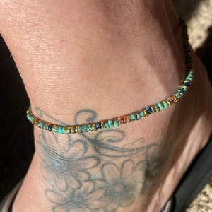 Detail of bohemian handmade beaded anklet featuring blue miyuki beads and gold accents