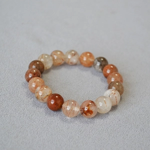Detail of 10mm red rutilated quartz beads showing natural needle-like inclusions