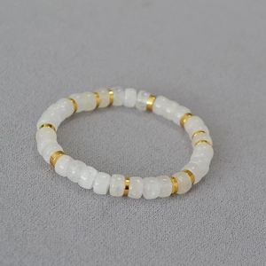 Macro detail of agate beads with golden spacers on a textured fabric background