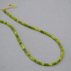 Détail du collier de perles en pierre vert olive vintage avec fermoir mousqueton doré et chaîne