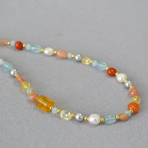 Dettaglio macro di perle barocche e pietre naturali in una collana di perle irregolare