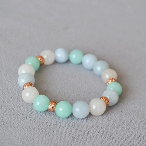 Detailed view of 10mm blue and green beaded stretch bracelet with rose gold metal spacers
