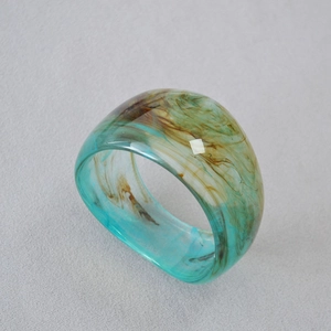 Vue détaillée d'une large bague en acrylique avec texture marbrée bleue et ambre
