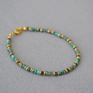 Detail of bohemian handmade beaded bracelet with turquoise stones and golden spacers