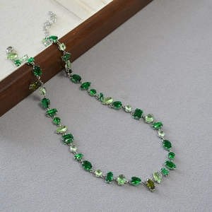 Detail of silver chain necklace with multi-shape green zircon gemstones and lobster clasp