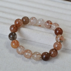Detailed macro view of 10mm red rutilated quartz beads with natural crystal textures