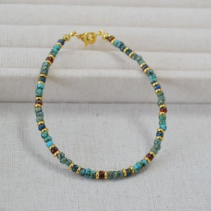 Detail of vintage bohemian beaded bracelet with turquoise stones and gold lobster clasp