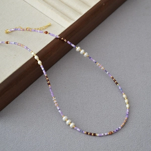 Elegant summer necklace featuring violet and white seed beads with pearls and gold chain