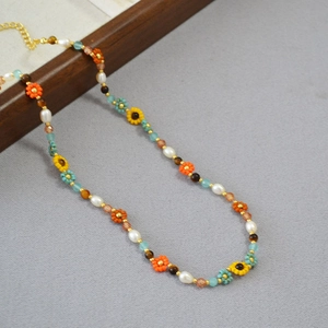 Détail du collier de perles et de tournesol avec perles colorées et chaîne en métal doré