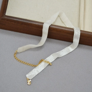 Detail of white woven bead choker necklace with gold adjustable chain and lobster clasp
