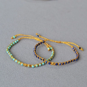 Détail de bracelets bohèmes en perles turquoise et lapis avec tissage réglable en fil doré