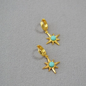Detail of gold-plated brass starburst earrings with turquoise stone inlays