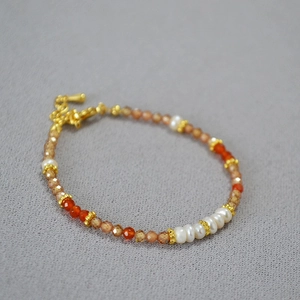 Détail du bracelet en perles d'eau douce avec zircon champagne et intercalaires dorés fins