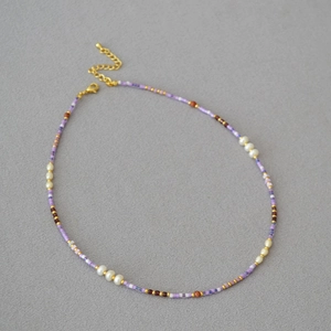 Detail of violet seed bead necklace with white pearls and gold adjustable clasp