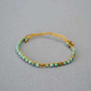 Détail du bracelet bohème fait main avec perles turquoise et fil doré tressé