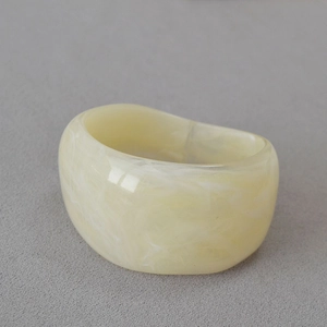 Vue macro d'une large bague en résine acrylique avec texture de marbre blanc laiteux
