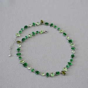Detail of green gemstone necklace with various cuts and adjustable silver chain