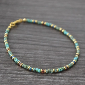 Detail of colorful beads with turquoise and red accents on a handmade bohemian bracelet