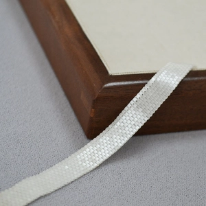 Detail of hand-woven white beaded ribbon necklace with delicate pearlescent mesh texture