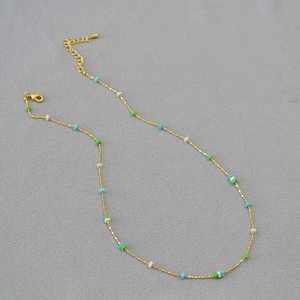 Detail of gold chain necklace with colorful square beads and adjustable lobster clasp