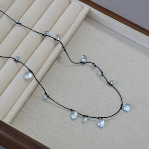 Dettaglio di un'elegante collana in cordoncino nero con ciondoli in cristallo lucente