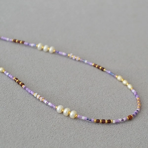 Detail of handmade beaded necklace with lavender beads and natural white pearls