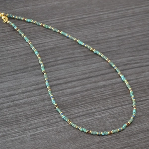 Detail of bohemian handmade beaded necklace with turquoise beads and gold lobster clasp