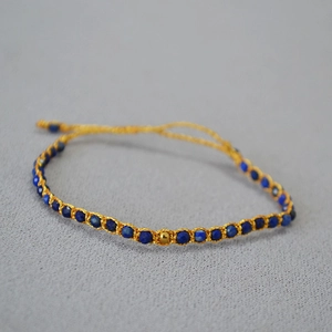 Vue macro de perles lapis-lazuli bohèmes avec un détail central de perle dorée