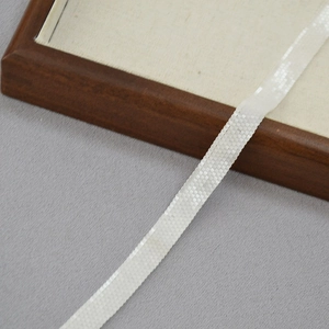 Detailed close-up of the elegant white hand-woven beaded ribbon necklace with mesh texture