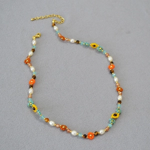 Détail du collier de perles fait main avec tournesols et motifs floraux bohèmes colorés