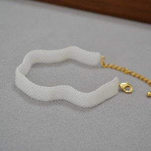 Detail of handmade white beaded wave necklace with adjustable gold-plated lobster clasp