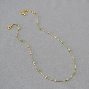 Detail of beaded gold chain necklace featuring colorful square stones and adjustable clasp