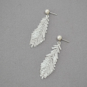Handmade woven leaf earrings with white seed beads and pearl studs on grey fabric