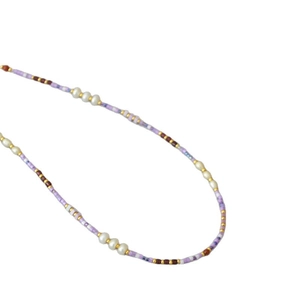 Bohemian purple and brown seed bead necklace with white baroque pearls on white background
