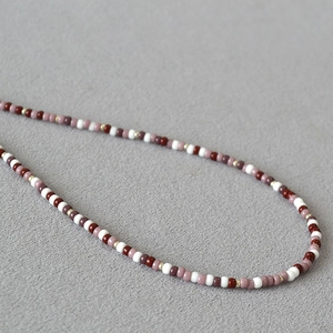 Macro shot of vintage bohemian necklace with wine red and purple Miyuki seed beads