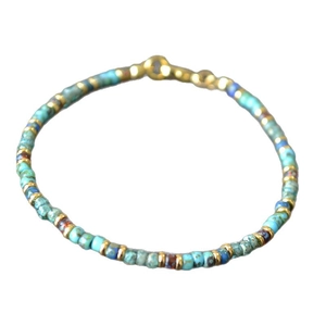 Bohemian handmade beaded bracelet featuring turquoise-colored beads and gold metal spacers