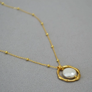 Irregular golden geometric ring pendant with baroque pearl on a beaded satellite chain