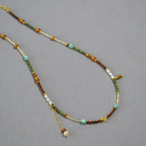 Détail de perles colorées, perles d'eau douce irrégulières et chaîne dorée du collier chic