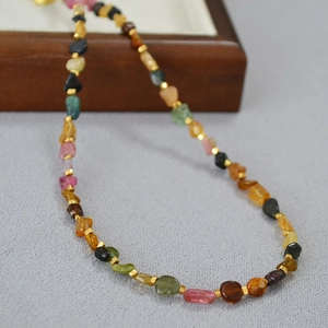 Macro detail of natural multi-color tourmaline beads and gold metal spacers on a necklace