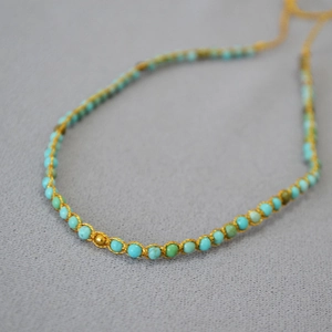Détail macro de perles turquoise tissées à la main avec fil doré de style bohème