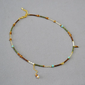 Détail du collier bohème en perles multicolores avec perles blanches et fermoir mousqueton doré
