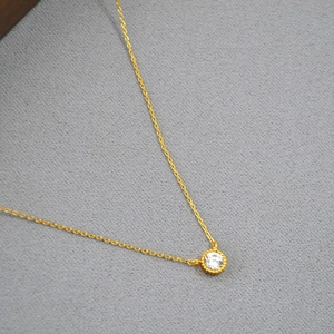 Minimalist gold plated brass necklace featuring a round solitaire cubic zirconia pendant