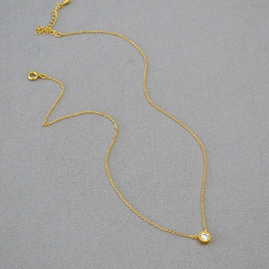 Minimalist gold plated necklace with a single round zirconia pendant on a thin chain