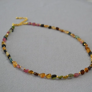 Macro detail of natural tourmaline beaded necklace with gold spacers and lobster clasp