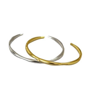 Minimalist brass open bangle featuring irregular wavy lines in gold and silver finishes