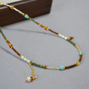 Collier bohème perlé avec perles vertes, chaîne dorée et perles d'eau douce blanches
