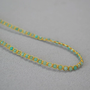 Vue macro de perles en turquoise et lapis-lazuli avec détails en fil d'or tissé