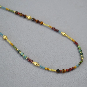 Gros plan détaillé du collier bohème avec perles de rocaille colorées et accents dorés